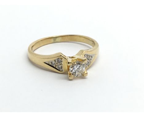 An 18carat bright gold ring set with a solitaire diamond approximately 0.20 of a carat the shank set with two further diamond