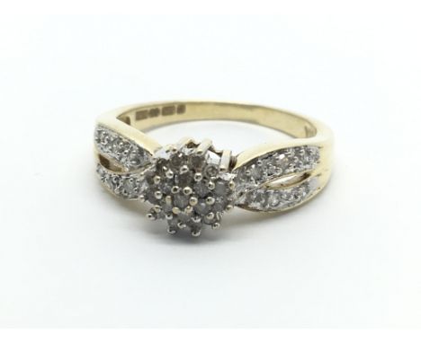 A 9carat gold ring set with a pattern of diamond with diamonds to the shank ring size M.