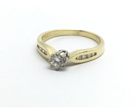 An 18ct gold solitaire diamond ring with further diamonds to the shoulders, approx .20ct, approx 2.7g and approx size K-L.