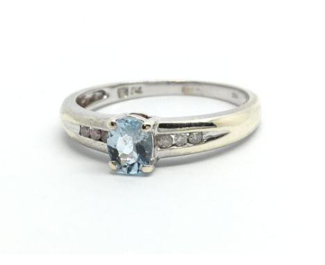 A 9ct white gold ring set with a central aquamarine and diamonds to the shoulders, approx 1.9g and approx size M.