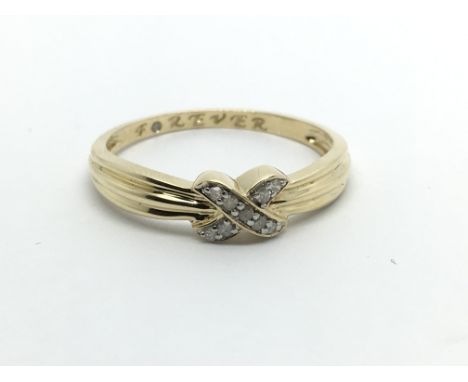 A 14carat gold ring set with a cross pattern of diamonds. Ring size V.