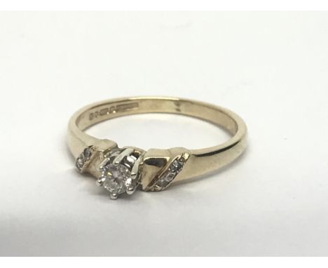 A 9ct gold solitaire diamond ring with further diamonds to the shoulders, approx.12ct, approx 1.9g and approx size I-J.