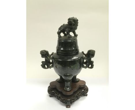 A carved jade jar and cover decorated with Fo dogs and raised on a hardwood stand, total approx height 22cm.