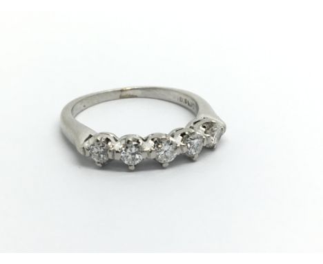 A Platinum ring set with a row of five brilliant cut diamonds ring size G.