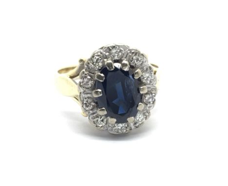 An 18carat gold ring set with a good size sapphire flanked by diamonds total weight 5.5g ring size I-J