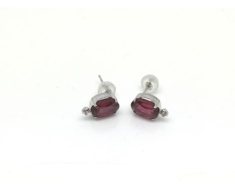 A boxed pair of 18ct white gold ruby and diamond studs, rubies approx 4ct, diamonds approx 0.06ct, approx weight 1.5g.