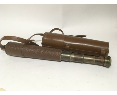 A brass three drawer telescope in a leather case.