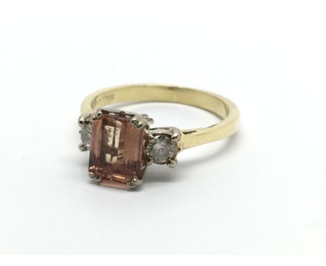 An 18carat gold ring set with a pink Topaz flanked by diamonds. Ring size L.