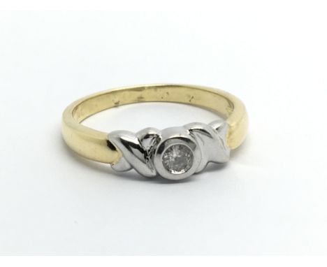 An 18carat gold ring set with a solitaire diamond flanked by white gold. Ring size L-M