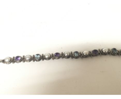 A silver (925) bracelet set with amethyst Colour and pearl With pale blue topaz type stones. With T bar clasp. Length 21cm