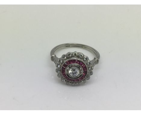 An Edwardian style platinum, ruby and diamond cluster ring with a central old cut diamond, approx 0.30ct, surrounded by calib