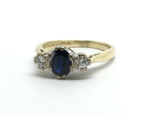 An 18ct gold ring set with a central sapphire and a diamond to either side, approx 3g and approx size H.