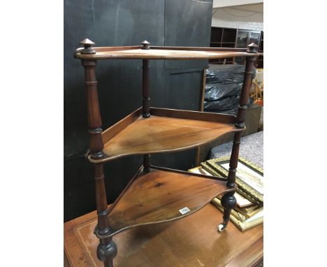 A Victorian mahogany three tier corner whatnot stand with pillar supports