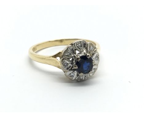 An 18carat gold ring set with a sapphire flanked by diamonds. ring size M-N