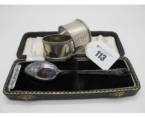 Two Hallmarked Silver Napkin Rings, (damages) one engine turned, both initialled, together with a hallmarked silver spoon, in