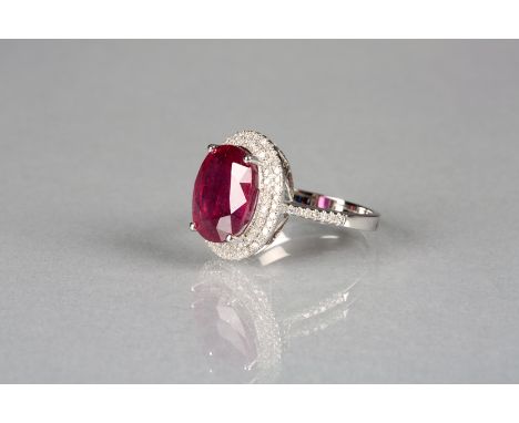 14k white gold and diamond set ring with an oval cut ruby approx. 6.60ct, total weight of diamonds approx. 0.75ct