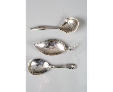 George III silver caddy spoon, leaf shaped design with engraved decoration, wire handle Assay marked London 1799, plus two ot