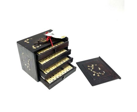 A wooden cased bone and bamboo mahjong set, the case inlaid with mother of pearl tooled leaves and associated brass carrying 