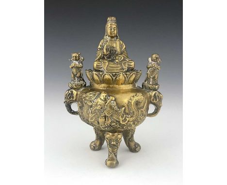 An Oriental bronze censer, modelled in relief with a figure on a dragon to each side, the lid with Guanyin seated, between el