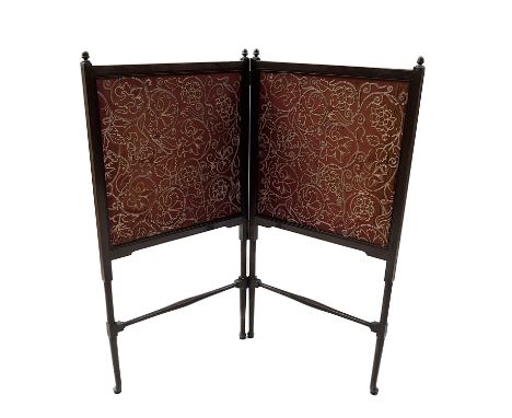 An Arts and Crafts walnut and silk embroidered bi fold fire screen, slender turned frame with two panels of foliate and flora