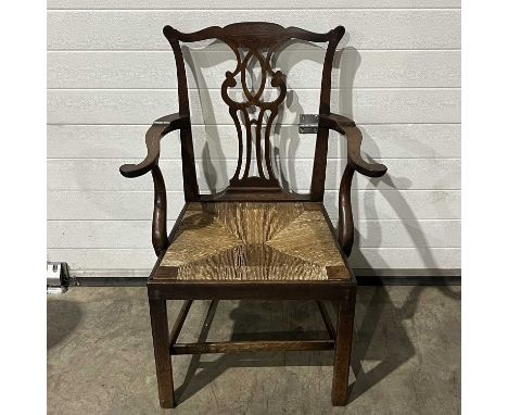 A George III oak rush seat armchair of Chippendale design, pierced splat, on block/sabre supports