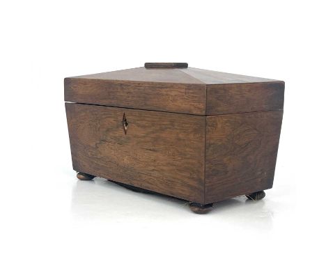 A Regency rosewood tea caddy, circa 1820, of sarcophagus form, fitted interiors with twin lidded compartments flanking a cent
