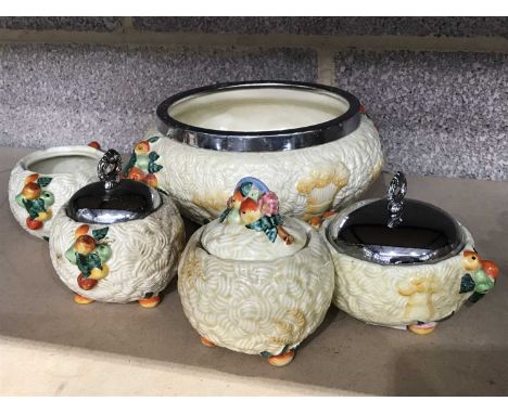 A collection of Clarice Cliff Harvest pattern tableware, including a chrome mounted fruit bowl, two chrome lidded preserve ja