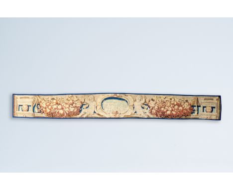 Full title: A large fragment of a Flemish wall tapestry with two putti with a cornucopia, 17th C.Description:459 x 50,5 cm