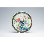A Chinese famille verte charger with pheasants on a rock surrounded by flowers, 19th C.