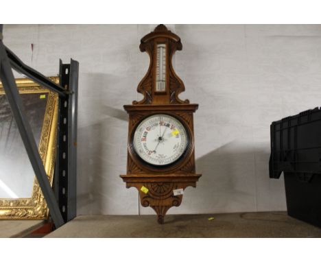 A late Victorian oak barometer, of traditional form with carved detail and thermometer scale  