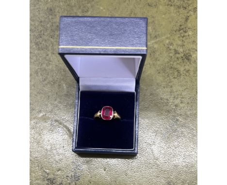 An 18ct yellow gold and synthetic ruby dress ring, size O.
