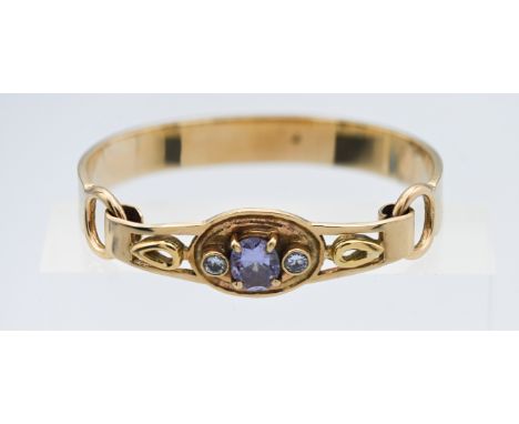 A yellow gold (not hallmarked) heavy gauge hook clasp bangle set with three stones in the centre, weight 33.4g