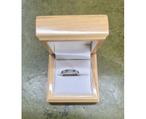 A white metal diamond and sapphire half band ring, size K/L, hallmarked rubbed.