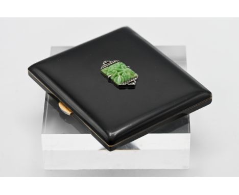 A black enamel compact fitted with a with mirror, the case set with carved jade and marcasite in a central design.