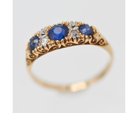 An 18ct yellow gold ring set with diamonds and three sapphires, size M