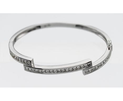 An 18k white gold set diamond zig zag channel set bangle, 36 princess cut diamonds with a hinged snap fitting, 19.6g
