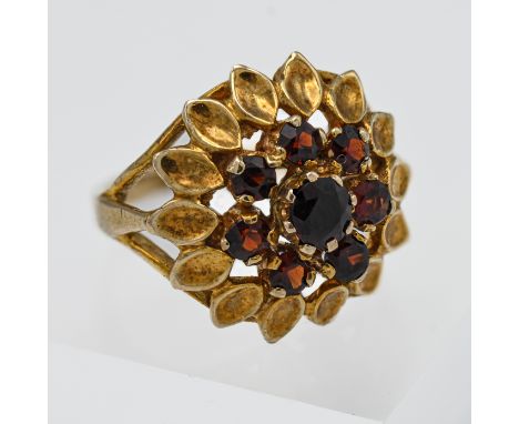 A 9ct yellow gold and garnet dress ring with leaf decoration, size K.