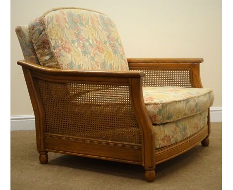 Ercol Bergere standard easy chair, ash frame, cane work sides, upholstered in a floral fabric, W90cm Condition Report Click h