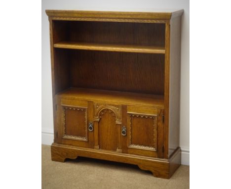 Medium oak open bookcase, single shelf above two cupboard doors with carved detailing, shaped plinth base, W84cm, H103cm, D26