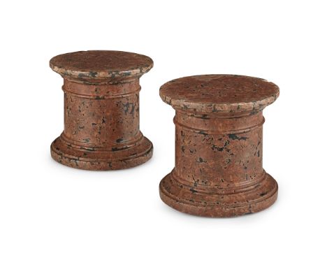 PAIR OF SMALL RED MARBLE STANDS EARLY 20TH CENTURY of cylindrical form, with ring carved spreading platform tops and correspo