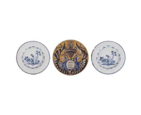 THREE DELFTWARE CHARGERS 18TH CENTURY comprising a pair of blue and white chargers decorated with flowers and bamboo with dot