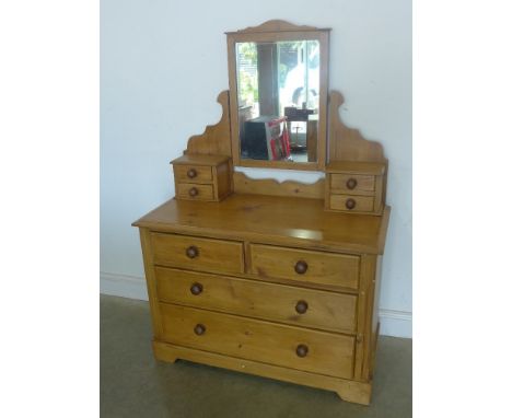 A Victorian stripped pine dressing chest with mirror back and four small jewellery drawers to top and two short over two long