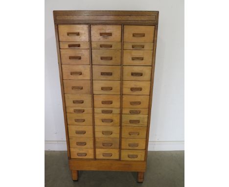 An oak veneered Shop cabinet with thirty three small drawers - Height 1.66 m x Width 79 cm x Depth 44 cm 
Condition report: C