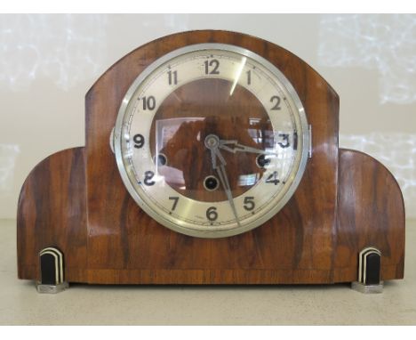 A walnut cased Art Deco style mantel clock with silvered chapter ring with Arabic numerals, three train movement