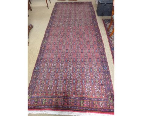 A rust ground handmade Persian Quashgai carpet - 3.90 m x 1.57 m