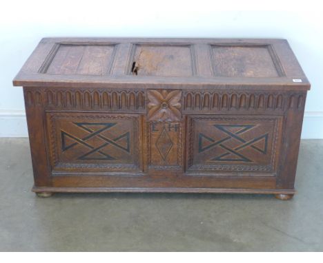 An oak two panel coffer, hinged lid raised on bun feet later decoration to front - 112 cm x 52 cm x 54 cm 
Condition report: 