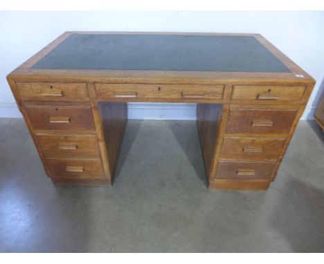 An oak veneered seven drawer twin pedestal desk - Height 76 cm x Width 1.38 m x Depth 79 cm 