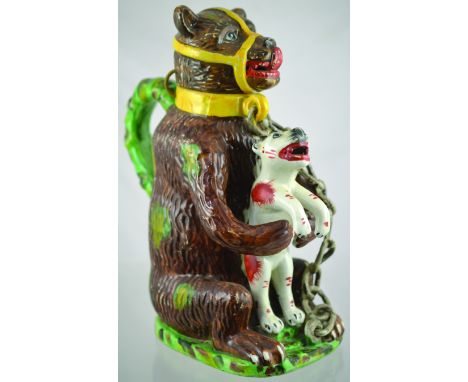 BEAR JUG. 11.75ins tall to top of bears head, chained & muzzled bear holding a dog in brown, green & yellow glaze. Dog in whi