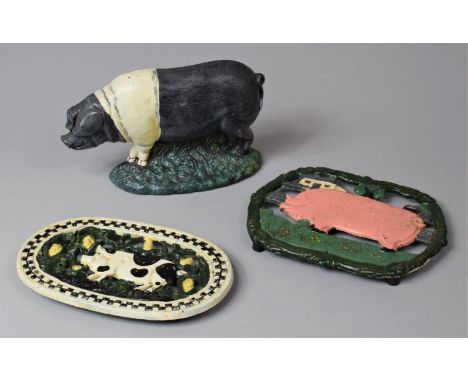 A Reproduction Novelty Cast iron Doorstop in the Form of a Saddleback Boar, together with Two Cast Iron Pig Teapot Stands 