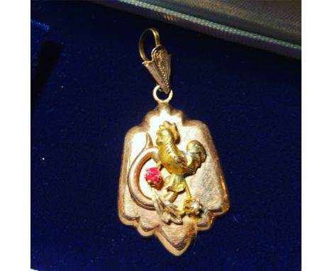Attractive Victorian gold plated shield shaped pendant with applied&nbsp;decoration including a cockrell. Set with a Ruby chi
